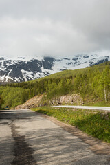 Asphalt road in the snowy Norwegian mountains