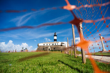 Low view through the red ribbons of the Barra Lighthouse, a postcard of the city of Salvador, Brazil.