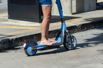 A person is seen riding an electric scooter on a street in the Barra neighborhood during a sunny day in the city of Salvador, Brazil.