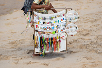 A street vendor is seen walking and carrying goods on the seafront of Barra beach during strong...