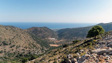Mountain view of Crete coastline with clear sky and lush greenery