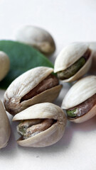 Close-up of Pistachios and Green Leaf on a White Background, Healthy Eating Concept