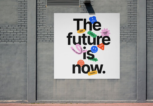 A blank square billboard is mounted on a gray brick wall in an urban setting. PSD template mockup