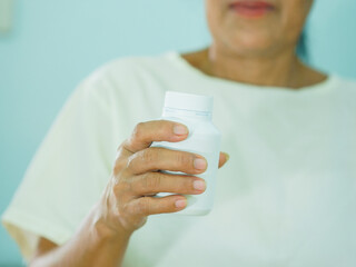Senior Asian woman holding drugs for concept healthcare and medical. Close up hand medicine bottle...