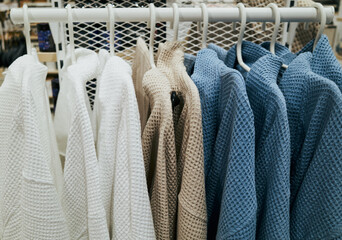 Rack of clothes with a blue and white jacket in the middle