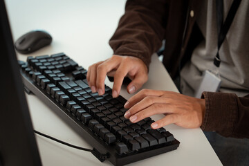 Person typing on black keyboard while working at desk, with computer mouse visible nearby. individual appears focused, suggesting tech related or customer support task