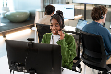 Smiling African American woman working customer support operator with headset. Female Call center...