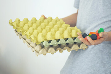 Practical eco-living choices. A man holds a collection of plastic lids and paper packaging, symbolizing minimal waste mindset and daily commitment to preserving nature and fighting plastic pollution
