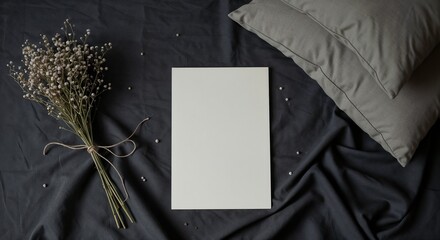 Fototapeta premium Blank white canvas on gray fabric with flowers and pillows 
