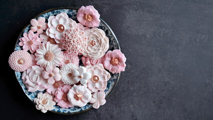 Sam Pan Nee, Thai dessert in pastel pink color tone with various flower shaped, Coconut milk flavor taste, Authentic Thai traditional handcraft snack in Dark background