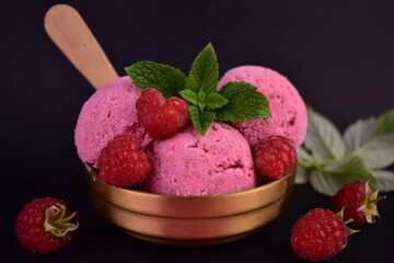 Raspberry ice cream on a black background. Close-up.
