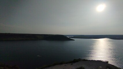 Fototapeta premium Panoramic View of River and Green Cliffs under Clear Sky