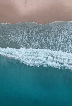Aerial Shot of a Wave Crashing on a Beach