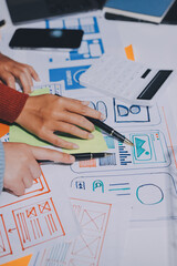 UX UI designer testing prototype on a phone, discussing and brainstorming on wireframes for a...