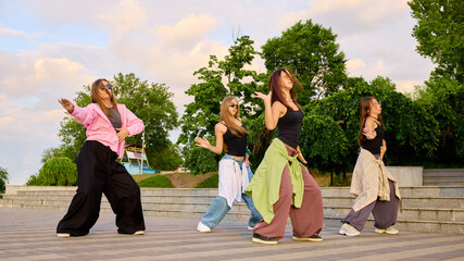Street dancers perform energetic moves on an outdoor paved area, showcasing a vibrant mix of styles and talents. Concept of urban expression and cultural diversity in dance.
