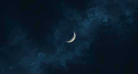 A crescent moon shining brightly in a dark blue night sky with wisps of clouds surrounding it