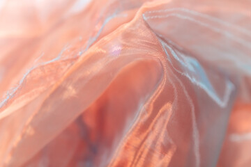 Close-up of pink translucent fabric with shimmer and soft folds, ideal for luxury fashion, bridal...
