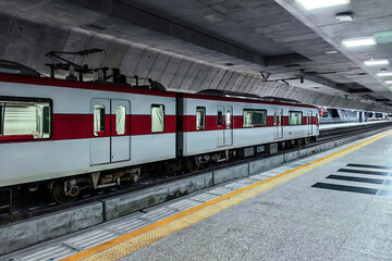 Fototapeta premium Electric underground tram with cables connected to upper carriage. Metro underground train. Tram station platform in tunnel. Metro station depicting ambiance of day travel. Concept of transportation.
