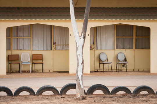 Chairs outside a pale yellow motel on the Nullarbor
