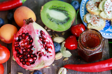 Pomegranate, kiwi, grapes and other fruits on a tray.