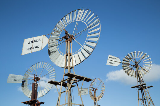 Four windmills against a blue sky
