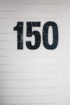 Number 150 Painted on Brick Wall