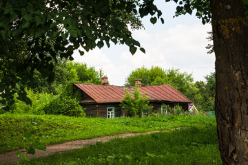 Kashin, Tver region, Russia - 9 July 2021: Old wooden residential typical Russian house among trees...
