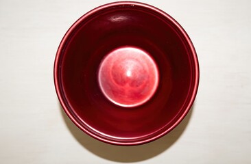 Modern flowerpot with bright red glossy finish on a light background