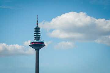 City TV tower close-up against the blue sky with clouds, television concept, media networks