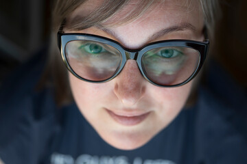 young blonde woman in glasses smiling looking at camera, street portrait. businesswoman, freelancer