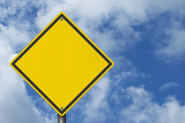 Blank yellow warning sign with cloudy sky