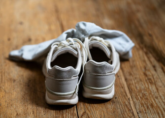 white sports shoes close-up with socks after training stand on a wooden floor. concept healthy lifestyle