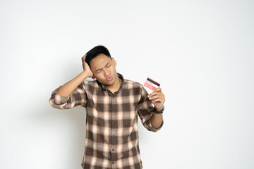 A young man expressing confusion while holding a credit card. Represents financial challenges, decision-making, or online transaction concerns.