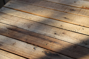 
Background of rustic wooden planks illuminated by sunlight. Diagonal view