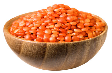 Uncooked red lentils in the wooden bowl, isolated on white background.