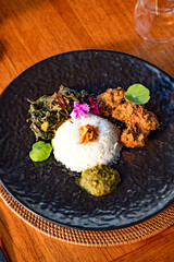 A beautifully arranged plate of Indonesian cuisine featuring rice and side dishes.