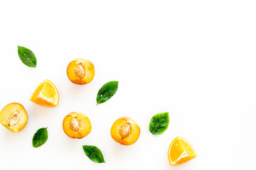 Peach slices and leaves pattern on white background top-down frame copy space
