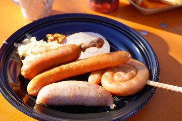 ソーセージとウインナーの豪華な盛り合わせプレート - ドイツ風とイタリア風の多様な肉料理が黒い皿に美しく盛り付けられた食欲をそそる一皿