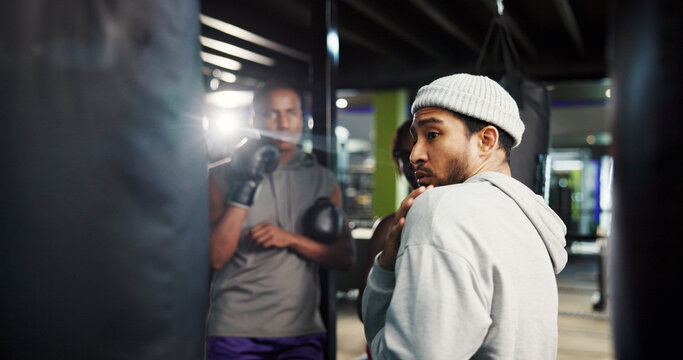 Fitness, trainer or teach defense in boxing with position, group session or training at punching bag. Man, coach or athletes in gym for instruction, combat technique or learning with sports challenge - Powered by Adobe