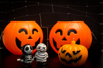 Calabazas con esqueleto y momia de juguete jugando al truco o trato
