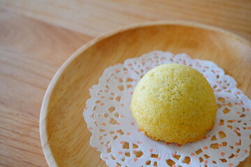 木製のお皿に盛られた黄色い和菓子まんじゅうの上品で伝統的な日本のお菓子
