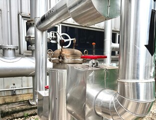 Industrial stainless steel pipeline system with red-handled gate valves. Used in HVAC, steam, and water distribution systems for factories, energy plants, or mechanical infrastructure.