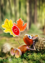 cute figure of acorns lying in moss in forest, children's creativity, DIY idea, with a sign with...