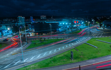 Long-exposure nighttime photography of moving vehicles on the streets of the northern part of Quito