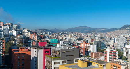 modern buildings in the northern part of Quito with mountains and blue sky in the background