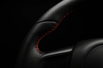 A close up of a steering wheel with red stitching