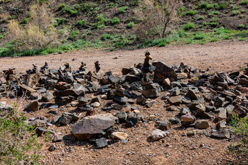 Small stone cairns arranged on rocky ground in a natural canyon setting
