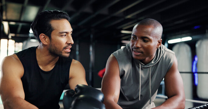Friends, boxing ring and men on break for fitness, sports or training advice in health club. Gym, boxer and resting together with athlete for fight technique, exercise or coaching with conversation