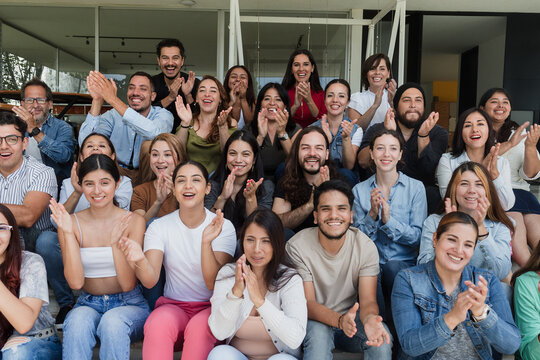 Diverse group of latin people applauding after successful conference in convention center in Mexico in Latin America, hispanic friends clapping in social meeting