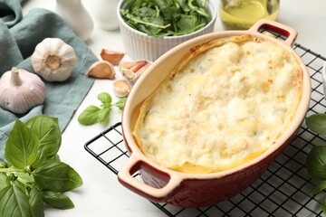Tasty vegetarian lasagna and ingredients on white marble table, closeup